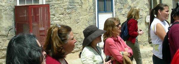 Adults looking at an instructor outside the museum